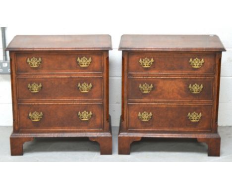 A pair of modern walnut three drawer chests with brass handles on bracket feet, width of both 65cm.