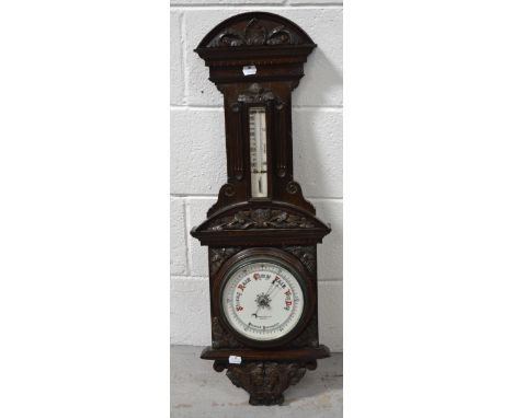 An early 20th century carved oak wall mounted barometer/thermometer, by Sharman D Neill Ltd, Belfast, height 80cm.