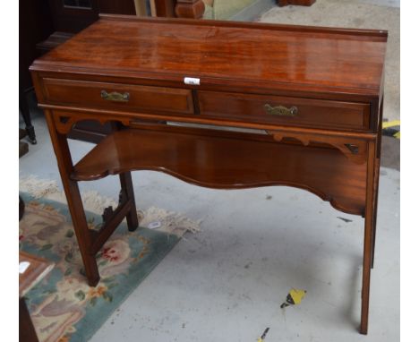 A mahogany side table with two short drawers above a shaped shelf.