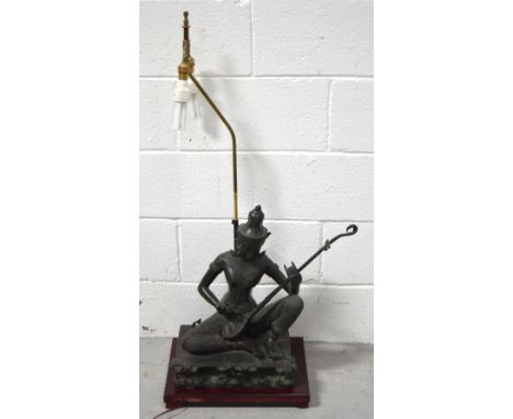 An Oriental lamp with double light in the form of a Siamese musician on a raised metal plinth decorated with prunus trees, he