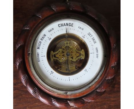 Carved oak framed circular aneroid barometer with enamelled dial. 19.5cms D
used not tested
