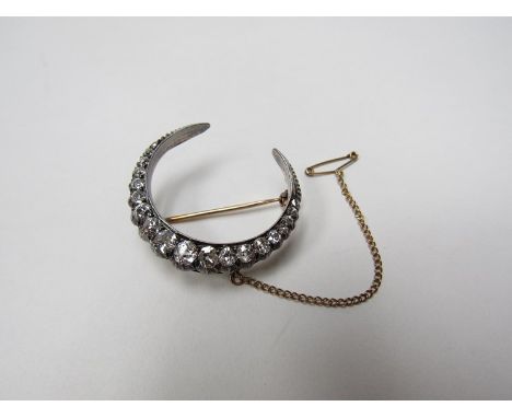 A diamond set crescent brooch, over 1.50ct diamonds approx., with safety chain 