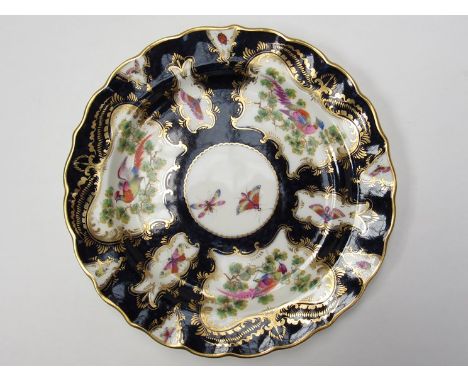 A Royal Worcester porcelain shaped circular plate in the 18th Century style: painted in polychrome enamels with exotic birds 