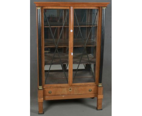 Biedermeier-Vitrine. Deutsch 19. Jh. Kirschbaum furniert, teilw. massiv und ebonisiert; vier Vierkantfüße, Schub, dreiseitig 