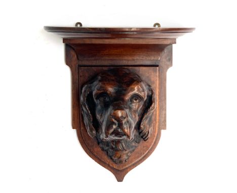An oak wall bracket, well carved with the head of a foxhound, 30cm high
