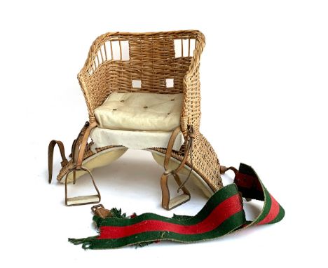 A vintage basket saddle, with wicker frame, felt back padding, leather cushion and stirrups, the girth in the Gucci colours, 
