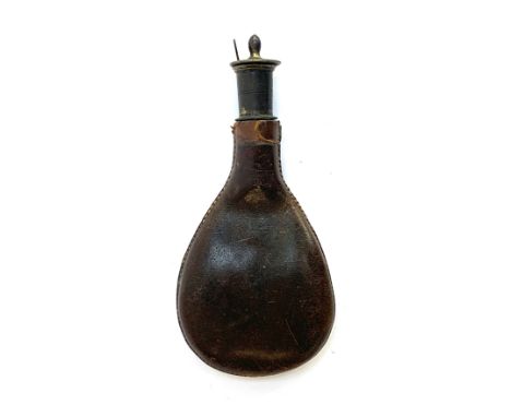 A leather powder flask, 18cm long, with removable measure, containing lead shot 