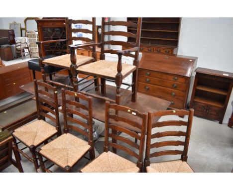 A set of six (4+2) 20th century oak vernacular chairs, having ladder backs with rush seats and turned legs