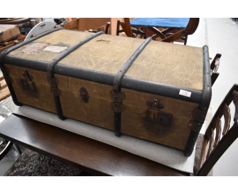 A vintage cloth bound travel trunk, bearing some luggage labels , approx. dimensions W92cm D54cm H33cm