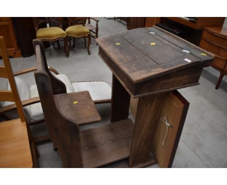 A 19th Century pitch pine school desk with integral chair on raised base, ceramic inkwells probably original , approx. Height