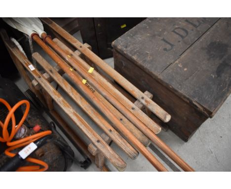 A vintage wooden sled/toboggan , stamped Davos , and a pair of wooden shafted oars