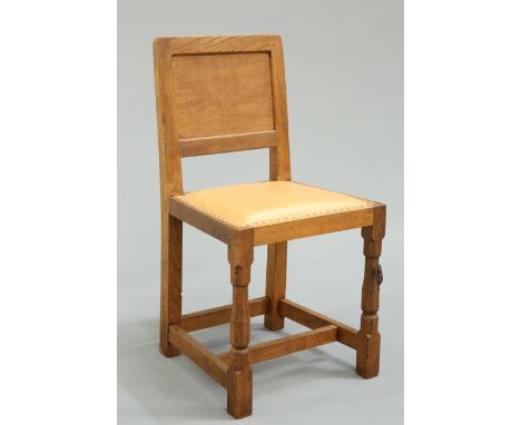 ROBERT THOMPSON OF KILBURNA MOUSEMAN OAK PANEL BACK CHAIR, CIRCA 1970, with brown hide upholstered seat raised on faceted bal