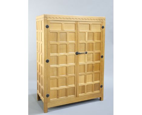 ROBERT THOMPSON OF KILBURN A MOUSEMAN OAK WARDROBE, with penny moulded crest above a pair of panelled doors with wrought iron