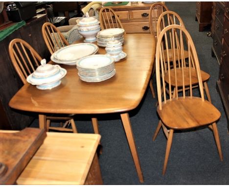 A set of six Ercol pale wood dining chairs, with hooped spindle backs and solid seats on tapered legs