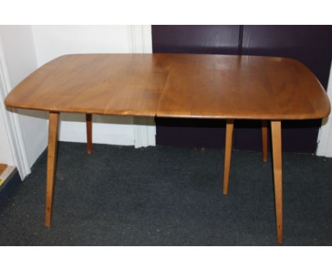 An Ercol pale wood extending dining table, with rounded rectangular top, on slanted tapering legs 153cm