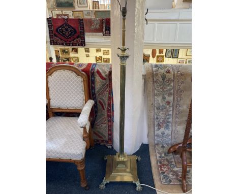 A brass corinthian column adjustable standard lamp on square stepped base with four cast paw feet  