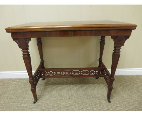 A Victorian walnut card Table with burr veneered rectangular fold-over top on cheval frame  having pierced frieze and casters