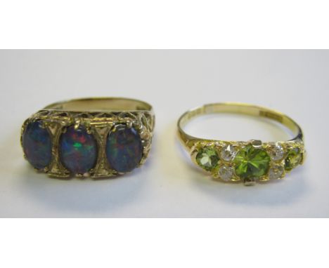 A Peridot and Diamond Ring pavé-set three graduated circular-cut peridots with two pairs old-cut diamonds between in 18ct gol