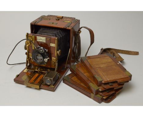 A Sanderson half plate Tropical hand and stand Camera, brass bound in teak with a Dallmeyer Stigmatic lens and three plate ho