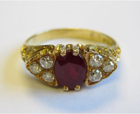 A Ruby and Diamond Ring pavé-set oval-cut ruby between, trios of old-cut diamonds in 18ct gold, ring size N 1/2