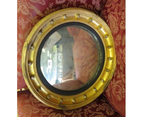 A Regency gilt circular convex Wall Mirror with ebonised slip and ball frieze