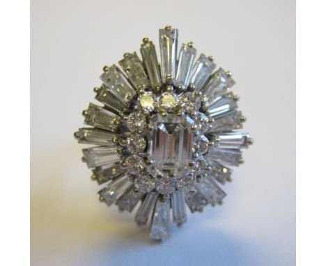 A Diamond Ballerina Ring corner claw-set step-cut stone within frame of brilliant-cut stones and outer frame of tapered bague