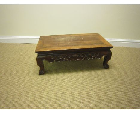 A Chinese hardwood low Occasional Table with shaped and scroll carved frieze on dwarf cabriole legs and ball and claw feet, 2