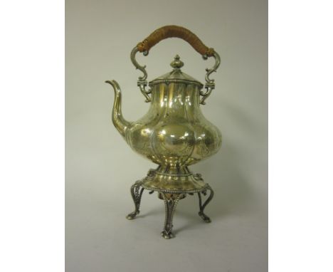 A large Victorian plated Tea Kettle with engraved decoration, cane covered handle on Stand with cabriole supports and spirit 