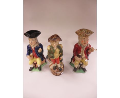 A 19th Century pottery Toby Jug of seated figure with sponged hat, red coat and yellow trousers, smoking pipe, 11 1/2in, pipe