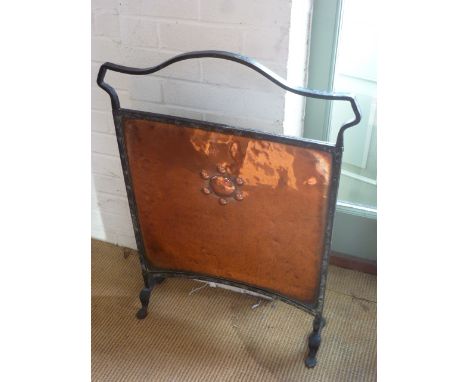 An Arts and Crafts copper and iron fire screen with embossed circular design to centre - Width 61cm x Height 87cm