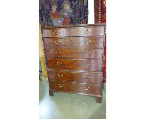 An early 19th century oak chest on chest of two short over three long graduated drawers on base of two long drawers raised on