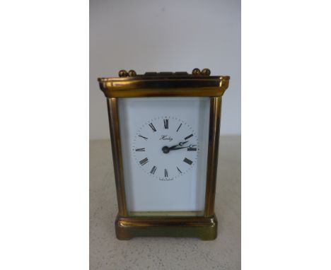 A brass cased carriage clock by Henley ,Roman numerals to white enamel dial