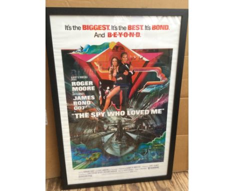 A framed and glazed James Bond film poster for 'The Spy Who Loved Me' signed by Sir Roger Moore with COA. Approx 66cm x 96cm 
