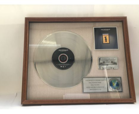 A framed and glazed limited edition platinum disc, CD and cassette display in recognition for worldwide sales of the Travelli