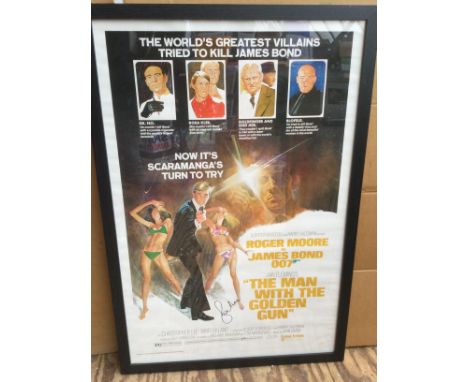 A framed and glazed James Bond film poster for 'The Man With The Golden Gun' signed by Sir Roger Moore with COA. Approx 66cm 