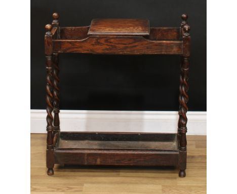 A Jacobean Revival oak walking stick or umbrella stand, central compartment with hinged cover, spirally-turned supports, 66cm