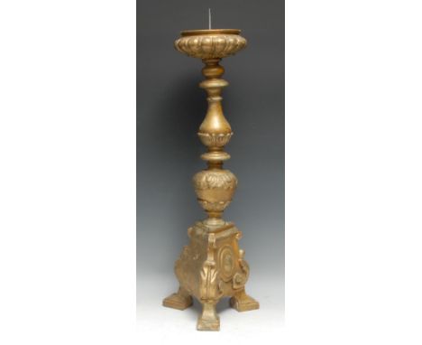 A substantial Baroque giltwood and gesso pricket candlestick, lobed compressed campana snonce, baluster pillar, triform base 
