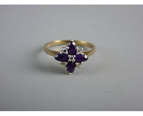 A NINE CARAT GOLD DRESS RING with four floral set oval amethysts and five tiny diamonds, 2.5 grms gross, size 'Q'