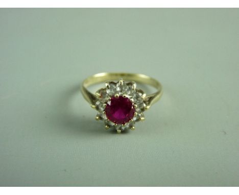 A NINE CARAT GOLD CENTRE RUBY & TINY CZ CLUSTER RING, 2.2 grms, size 'O'