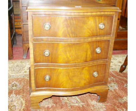 A NEAT REPRODUCTION MAHOGANY SERPENTINE FRONT THREE DRAWER CHEST with brass ring handles and on bracket feet, 53 cms wide