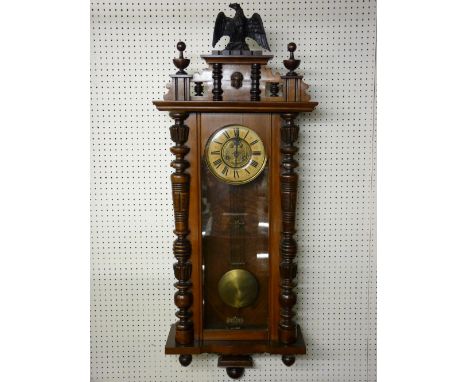 A WALNUT CASED PENDULUM DRIVEN VIENNA STYLE WALL CLOCK, the dial set with Roman numerals and stylized floral brass centre, th