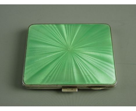 AN ENGINE TURNED LADY'S SILVER CIGARETTE CASE with a green enamel lid, 3 troy ozs, Birmingham 1940