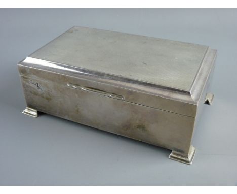 AN OBLONG SILVER CIGARETTE BOX on corner bracket feet and with engine turned lid, two compartment wooden interior, Birmingham