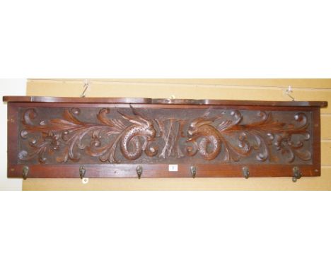 A VINTAGE MAHOGANY COAT RACK & SHELF with carved panel of mythical beasts and central 'W A' monogram, 27.5 cms high, 113 cms 