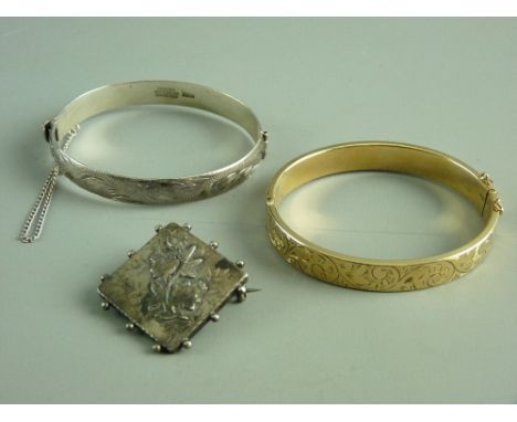 A NINE CARAT GOLD (with metal core) HALF BRIGHT CUT OVAL BANGLE, 14 grms, a similar sterling silver bangle, 24 grms and a sma