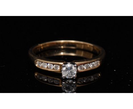A new diamond ring, central round brilliant cut solitaire diamond, raised above flanking shoulders each set with four smaller