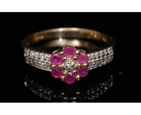 A new ruby and diamond flower head cluster ring, central diamond surrounded by six round cut ruby's, tapering shoulders set w
