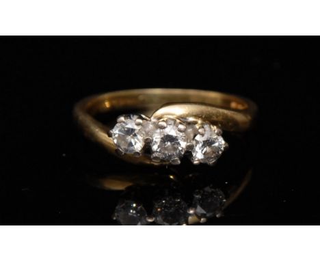 A three stone diamond cross over ring, three round brilliant cut diamonds, total diamond weight approx 0.50ct, 18ct gold shan