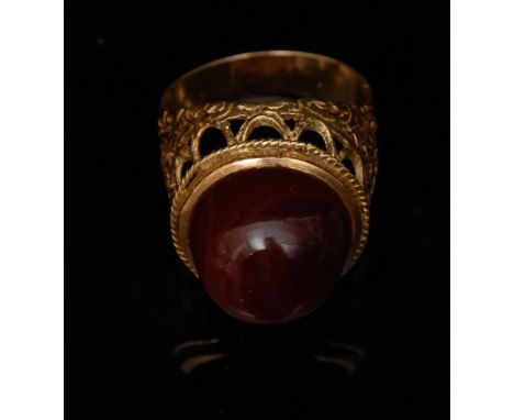 An Iranian banded agate domed cabochon signet ring, the orange red stone with multiple arching bands, open tapering crown cla