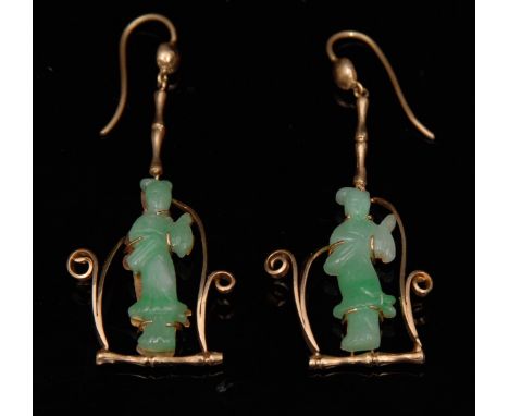 A pair of Chinese carved Jade and yellow metal drop earrings, each carved as a Geisha Girl within cradle, suspended from a ba